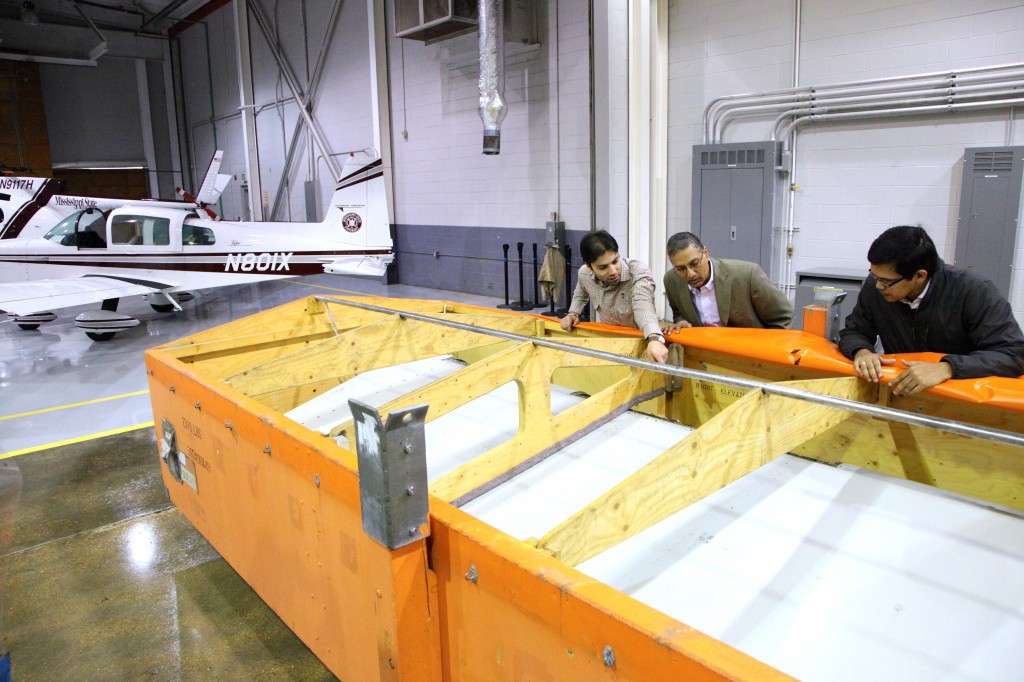 From L-R: Aerospace graduate student Ashkan Khalili, Raspet director Ratan Jha and research associate Dulip Widana-Gamage preparing to unpack the elevator in the Raspet hangar.