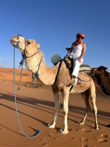Allie Cooper rides a camel while visiting the Sahara Desert.