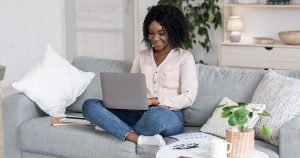 Joyful Woman Working On Laptop On Couch At Home, 