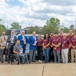 A group of people standing in front of the EcoCar.