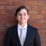 Headshot of Josh Brown with brick background.